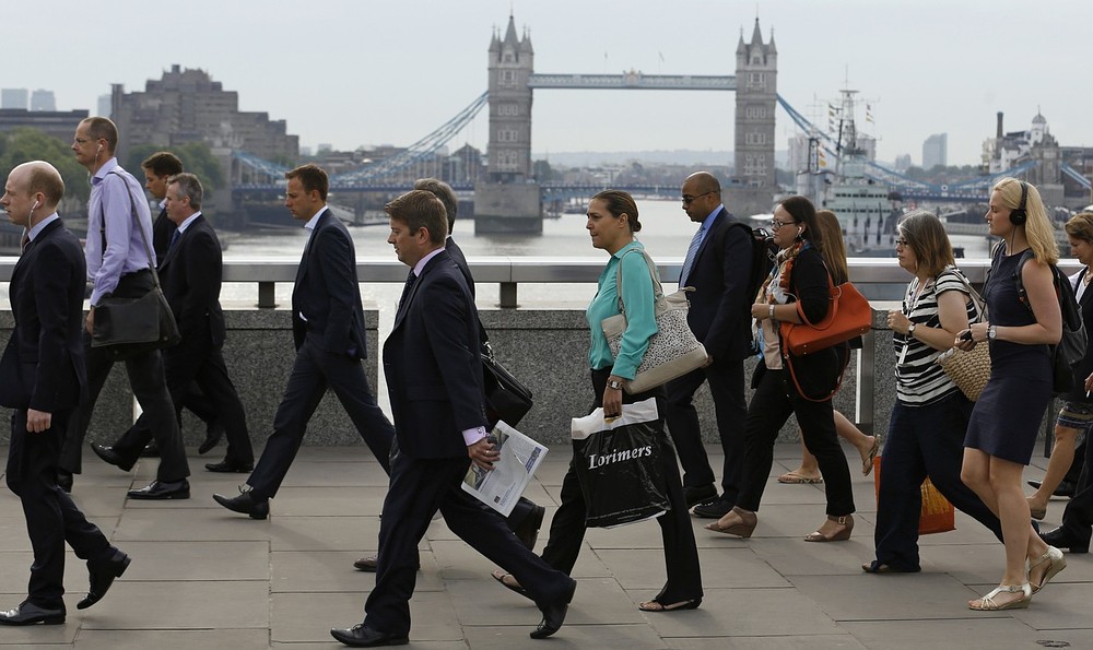Commuters walk across London Bridge to the City of London August 7, 2013. The Bank of England broke with tradition on Wednesday, saying it planned to keep interest rates at a record low until unemployment falls to 7 percent or below, which it views as unlikely for another three years. REUTERS/Luke MacGregor (BRITAIN - Tags: BUSINESS EMPLOYMENT)