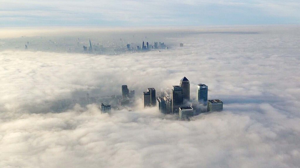 The Canary Wharf financial district (front) and central London emerge from morning fog in this aerial photograph released by the Metropolitan Police in London March 13, 2014. REUTERS/Metropolitan Police/Handout via Reuters (BRITAIN - Tags: BUSINESS CITYSCAPE ENVIRONMENT TPX IMAGES OF THE DAY) ATTENTION EDITORS - THIS IMAGE WAS PROVIDED BY A THIRD PARTY. FOR EDITORIAL USE ONLY. NOT FOR SALE FOR MARKETING OR ADVERTISING CAMPAIGNS. THIS PICTURE IS DISTRIBUTED EXACTLY AS RECEIVED BY REUTERS, AS A SERVICE TO CLIENTS. NO COMMERCIAL OR BOOK SALES. NO SALES. NO ARCHIVES. NO THIRD PARTY SALES. NOT FOR USE BY REUTERS THIRD PARTY DISTRIBUTORS