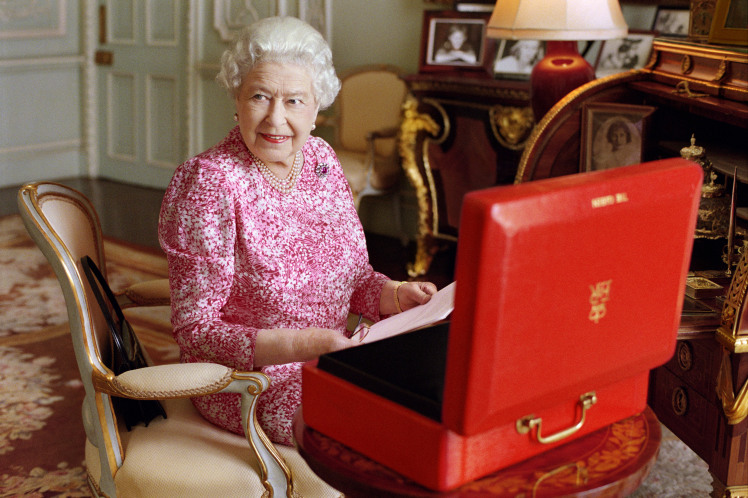 LONDON, UNITED KINGDOM - JULY 2015: (This image is free of charge for a month from release. Use or reproduction in any format on any platform after October 8, 2015, must be approved first by Royal Communications at Buckingham Palace.)  In this handout photo released by Buckingham Palace on September 8, 2015, Queen Elizabeth II is seated at her desk in her private audience room at Buckingham Palace with one of her official red boxes which she has received almost every day of her reign and contain important papers from government ministers in the United Kingdom and her Realms and from her representatives across the Commonwealth and beyond. The photo has been taken by Mary McCartney in July 2015, to mark the moment she becomes the longest reigning British Monarch. (Photo by Mary McCartney/Her Majesty Queen Elizabeth II via Getty Images)