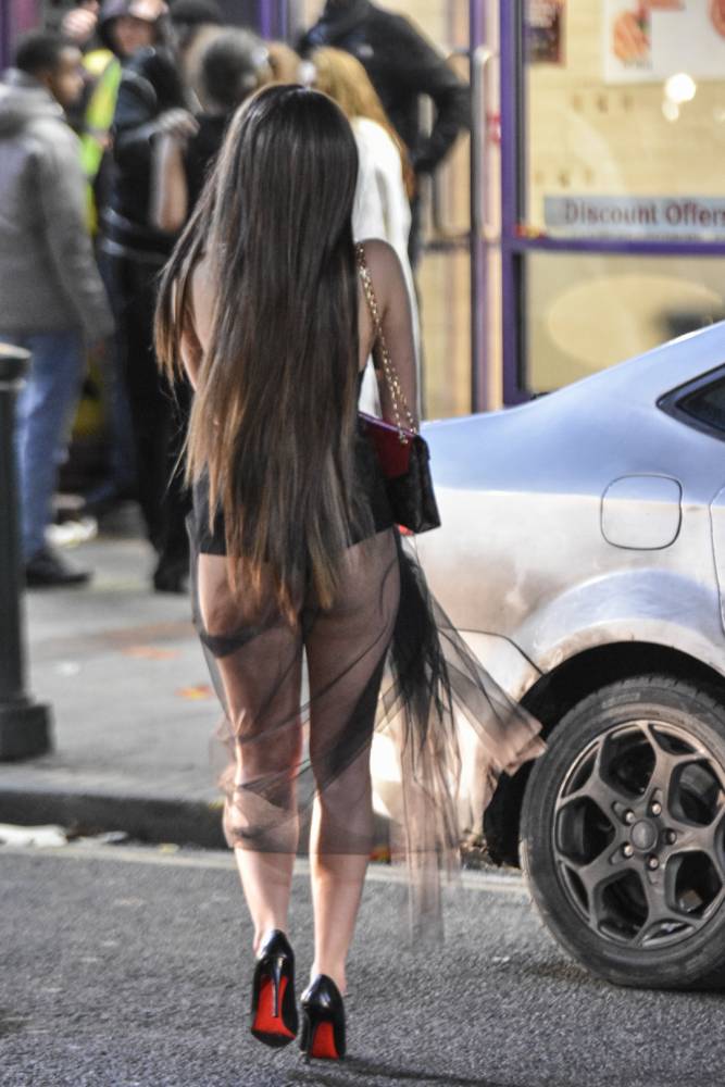 Birmingham, United Kingdom. 1st January 2016 -- A woman crosses the road wearing a skimpy outfit on Birmingham's Broad Street in the early hours of New Year's Day. -- Party-goers in Birmingham drank to excess and suffered the effects. Drunk louts fought with each other and were arrested on Broad St. West Midlands Ambulance Service set up a triage in the Library of Birmingham to deal with additional NYE patients.