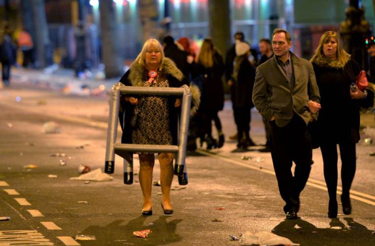 Revellers head home as the clean-up begins in central London after the New Year celebration fireworks. PRESS ASSOCIATION Photo. Picture date: Friday January 1, 2016. Photo credit should read: Anthony Devlin/PA Wire