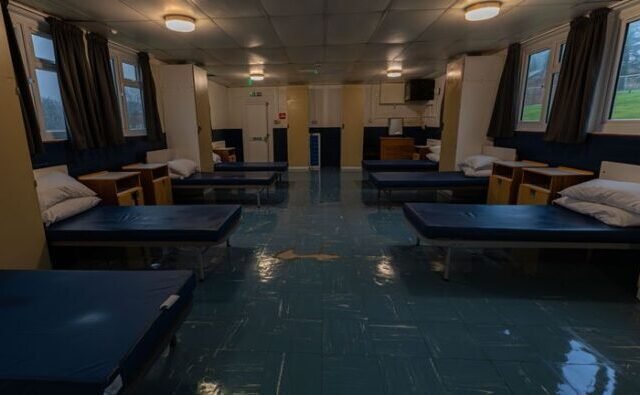 Megkezdték a migránsok áttelepítését egy angliai katonai táborba – hetek óta tartó tiltakozás ellenére